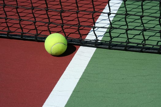 A Tennis Ball out of bounds with white line and net