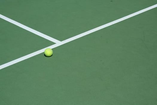 A Tennis ball on a green court