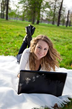 Young woman in park with laptop