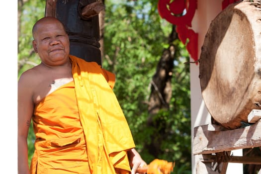 Buddhist monk beating the drum in the temple complex