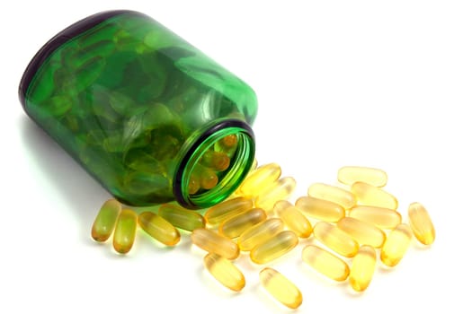 Green bottle and pills on white brackground