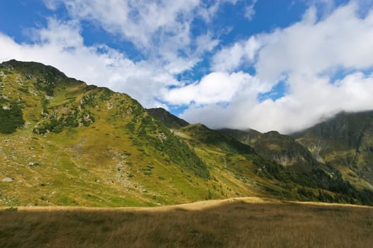 a range of mountains and a sky with clouds