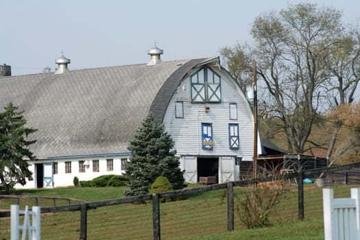 A white barn with fence and sky