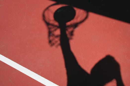 A Shadow Basketball player dunking on red court