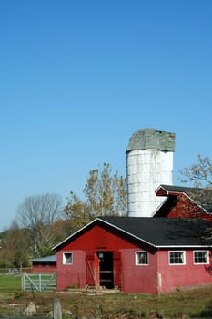 A Red Barn and silo against blue sky