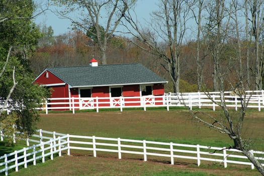 A Red Barn and white horse fence