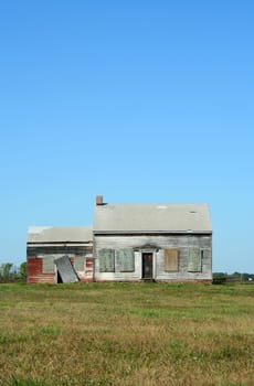 An Old abandoned house with grass and sky