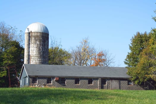 A Barn and silo against a blue sky