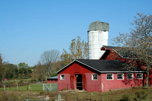 A Red Barn and silo against blue sky