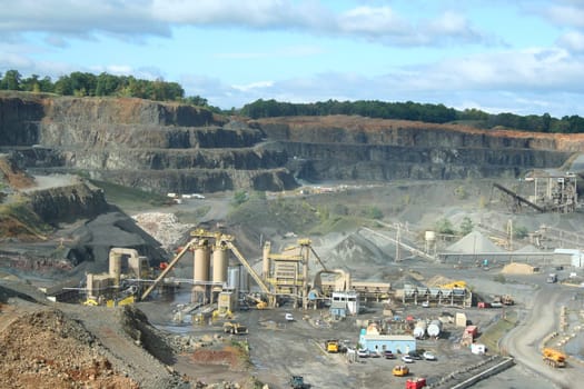 A Rock Quarry with equipment and trucks