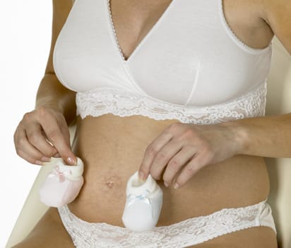pregnat woman with shoes for babies