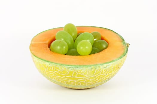 Grapes in a hole of melon isolated on white