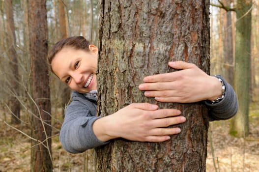 Young woman hugging a tree