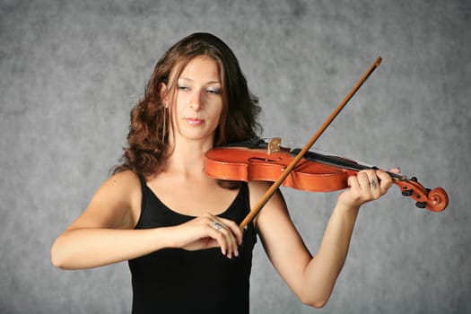 portrait of sexy brunette with violin on the grey background