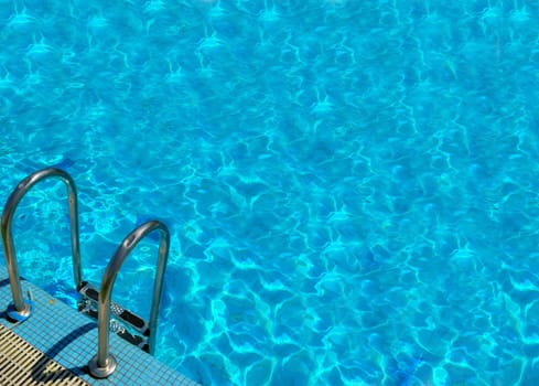 pattern of water of swimming pool with light in it and pool&#039 s stairway