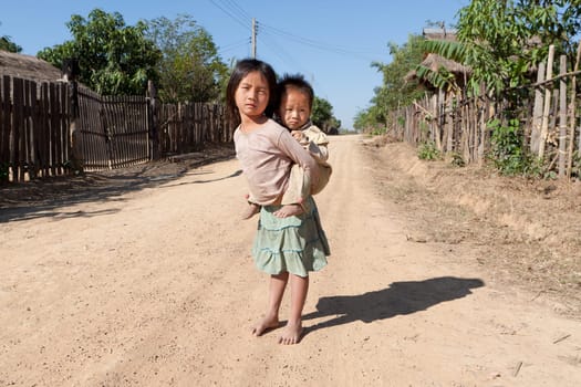 Children in poverty,sister has little brother piggybacking