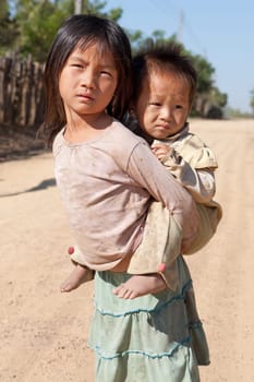Children in poverty,sister has little brother piggybacking