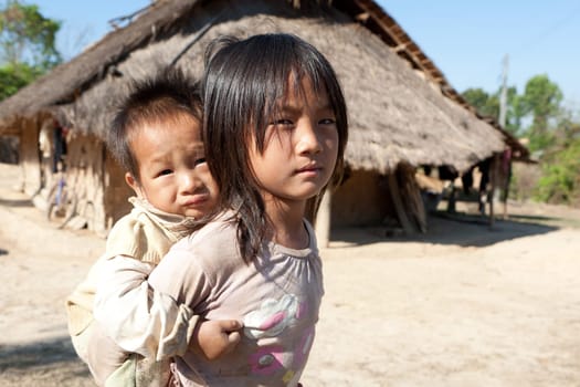 Children in poverty,sister has little brother piggybacking