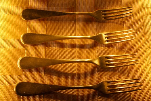 four vintage silver forks on the candle light