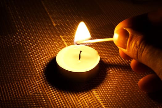 Candle ignition with match in the evening night