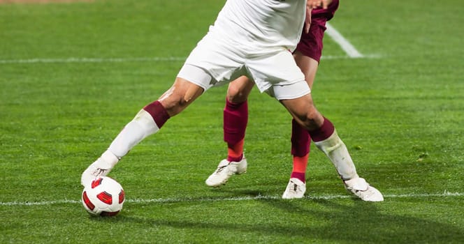 Soccer players running after the ball