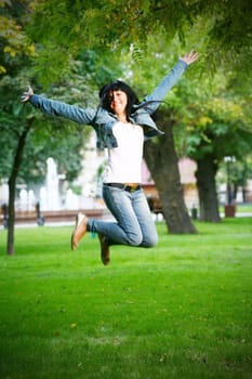 photo of young woman jamping on a grass
