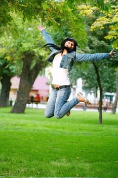 photo of young woman jamping on a grass
