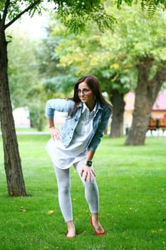 a young gorgeous woman is standing on the grass