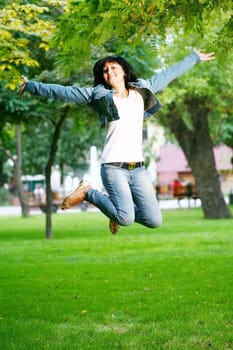 photo of young woman jamping on a grass