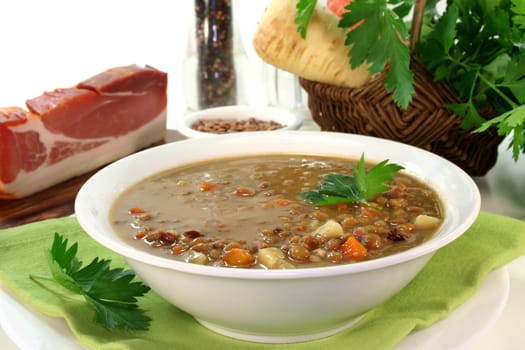 a bowl of lentil soup with bacon and parsley