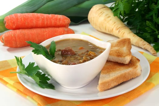 a bowl of lentil soup with bacon and parsley