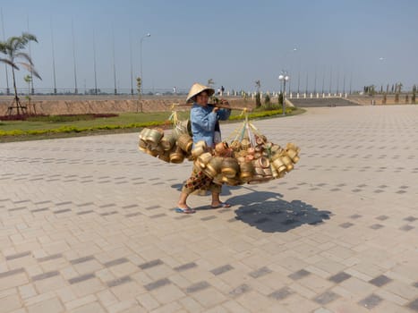 Street vendor Laos,heavy load with baskets on pole