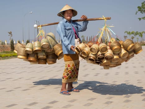 Street vendor Laos,heavy load with baskets on pole