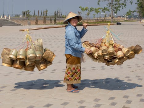 Street vendor Laos,heavy load with baskets on pole