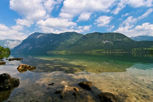 few rocks on the shore of a mountain lake