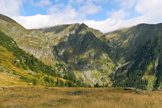a range of mountains and blue sky with clouds