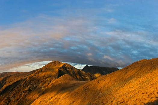 reflection sunrise on a mountain slope under a cloud