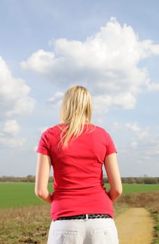 Lonely young woman on a dirt road