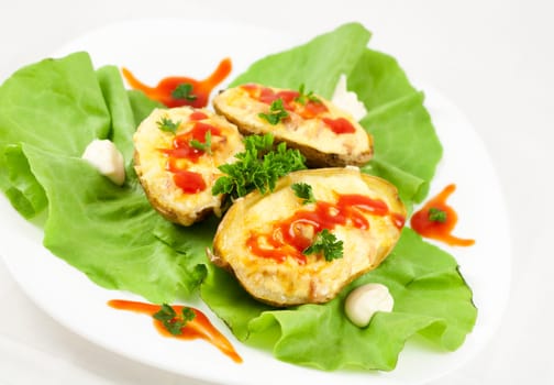 Baked potatoes filled with ham, eggs and cheese, decorated with parsley, ketchup, mayonnaise and lettuce