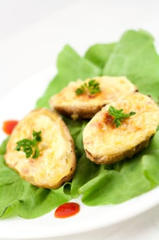 Baked potatoes filled with ham, eggs and cheese, decorated with parsley, ketchup and lettuce