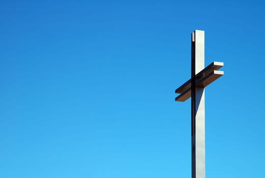 detail photo of a steel cross, blue sky,