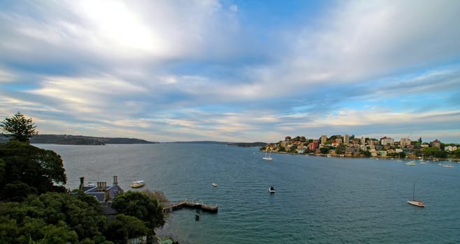 ocean panorama, cloudy sky, water, boats anchoring,