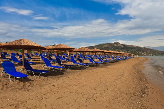 a beach filled with sun beds in Zakynthos, Greece
