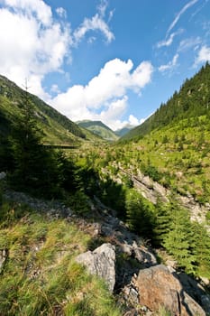 a mountain slope and a blue sky with clouds