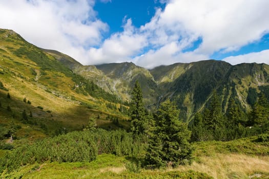 a range of mountains and blue sky with clouds