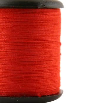 Red spool of thread over white
