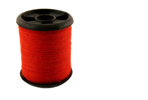 Red spool of thread over white