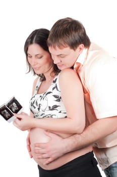 Happy young couple holding a sonogram of their child