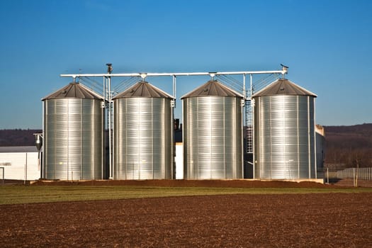 beautiful landscape with silo and snow white acre with blue sky