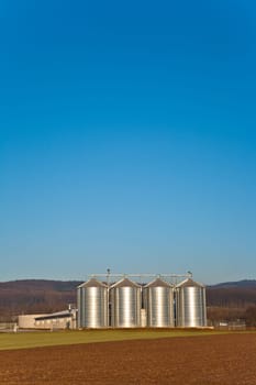 beautiful landscape with silo and snow white acre with blue sky